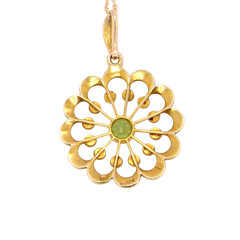 rear pendant from the Edwardian- Age of Elegance-
The centre stone- a round peridot 5mm diameter, mille grain set. A satellite perimeter of twelve seed pearls, each 2.4mm. The outside border is scalloped shaped and each crescent is set with tiny seed pearls.