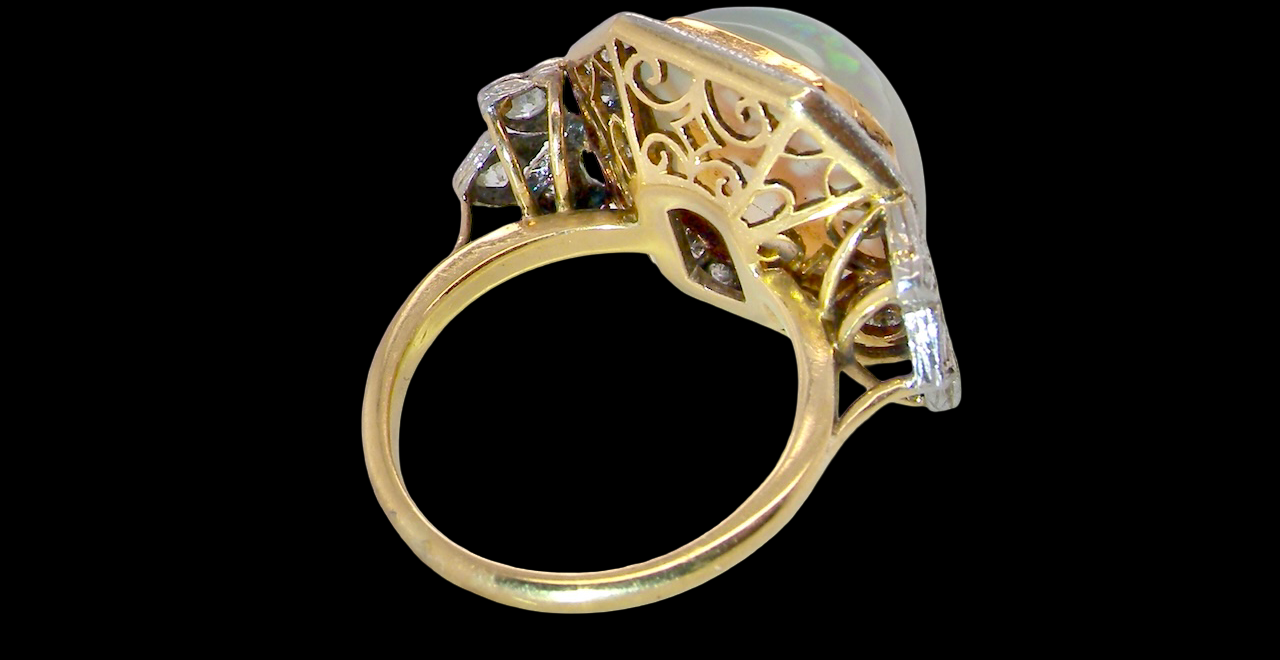 rear view cabouchon cut opal shown is cushion shaped, measures 15x13 (5.78 carats) displaying a mass of vibrant colours, from flashes of fireglow orange, luminous greens, and lavender purples.