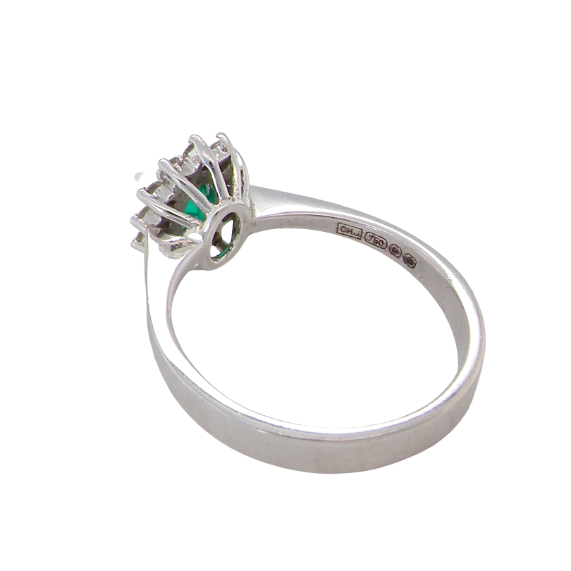 rear white gold cluster ring.
Centre stone is an oval cut emerald, 6x3.7mm (just under 0.50 carats) good deep green hue.