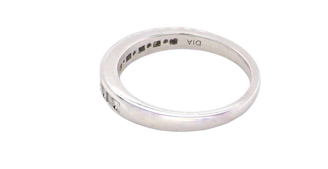 rear An 18 carat white gold half hoop eternity ring. Mixed cuts of white diamonds which consist of seven round brilliant stones, each 2mm diameter and eight baguette cut stones, each 2x1.5mm. Estimated total 0.50 carats.