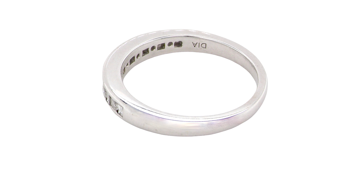 rear An 18 carat white gold half hoop eternity ring. Mixed cuts of white diamonds which consist of seven round brilliant stones, each 2mm diameter and eight baguette cut stones, each 2x1.5mm. Estimated total 0.50 carats.