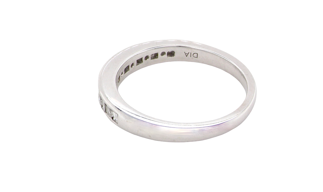 rear An 18 carat white gold half hoop eternity ring. Mixed cuts of white diamonds which consist of seven round brilliant stones, each 2mm diameter and eight baguette cut stones, each 2x1.5mm. Estimated total 0.50 carats.