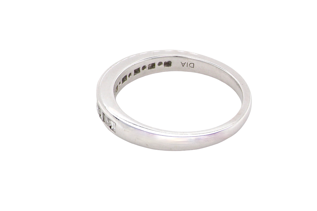 rear An 18 carat white gold half hoop eternity ring. Mixed cuts of white diamonds which consist of seven round brilliant stones, each 2mm diameter and eight baguette cut stones, each 2x1.5mm. Estimated total 0.50 carats.