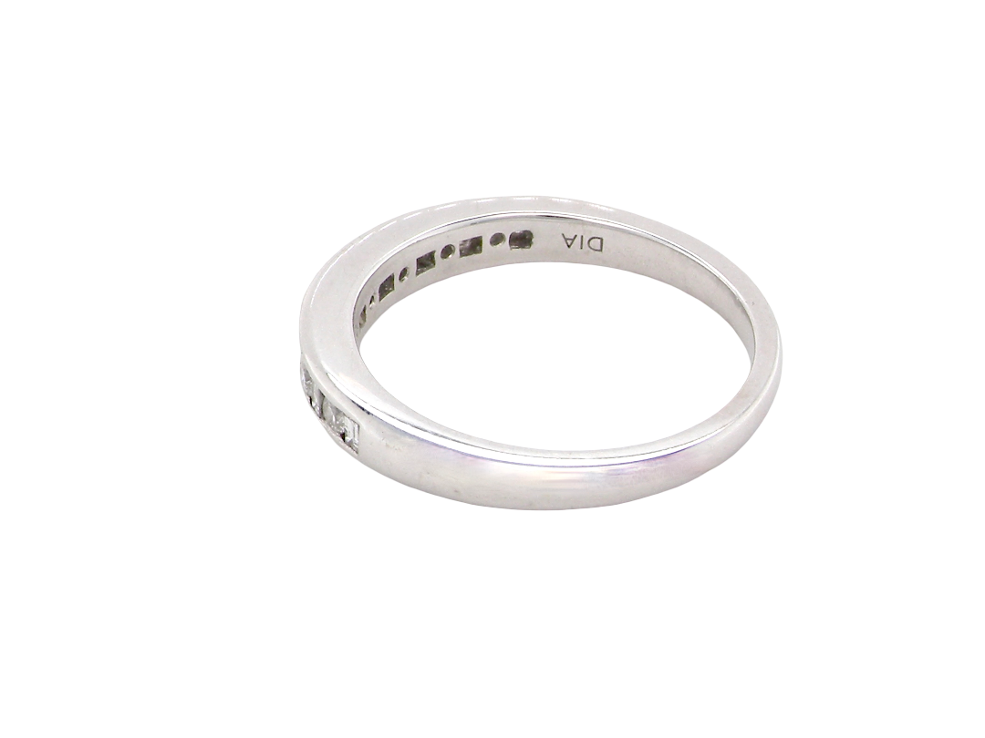rear An 18 carat white gold half hoop eternity ring. Mixed cuts of white diamonds which consist of seven round brilliant stones, each 2mm diameter and eight baguette cut stones, each 2x1.5mm. Estimated total 0.50 carats.