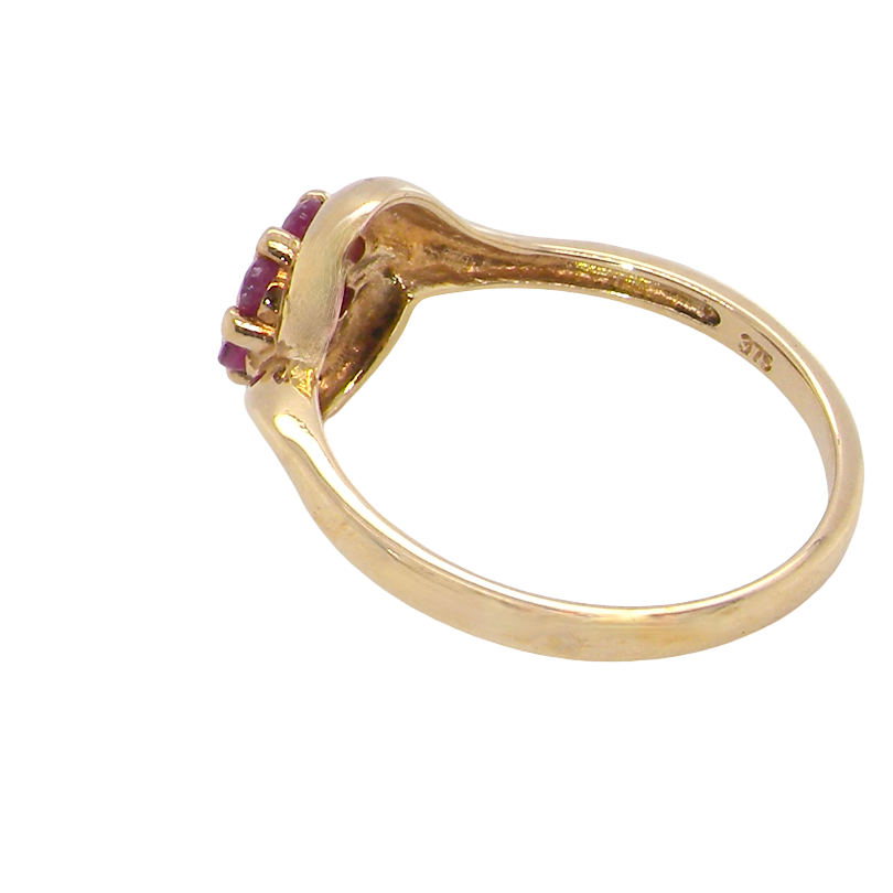 rear A modern 9 carat gold cluster ring. At the centre a small diamond, this complimented by an outer halo of six 2.4mm rubies (each 0.05 carats)