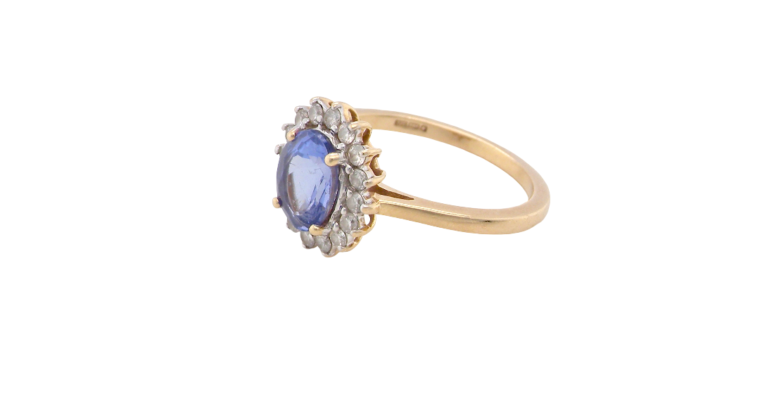 side A 14 carat gold cluster ring. Features to the centre an oval cut cornflower blue sapphire, 8x6mm (est 1.25 carats), four claw setting.