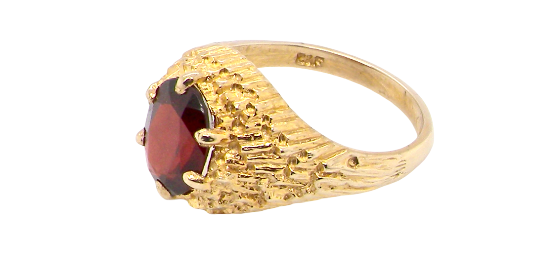 side A 1970s dress ring set with an oval garnet stone. This measures 10x8mm and claw set.