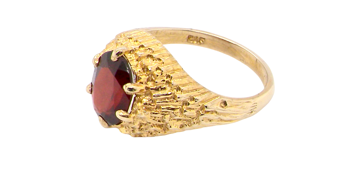 side A 1970s dress ring set with an oval garnet stone. This measures 10x8mm and claw set.