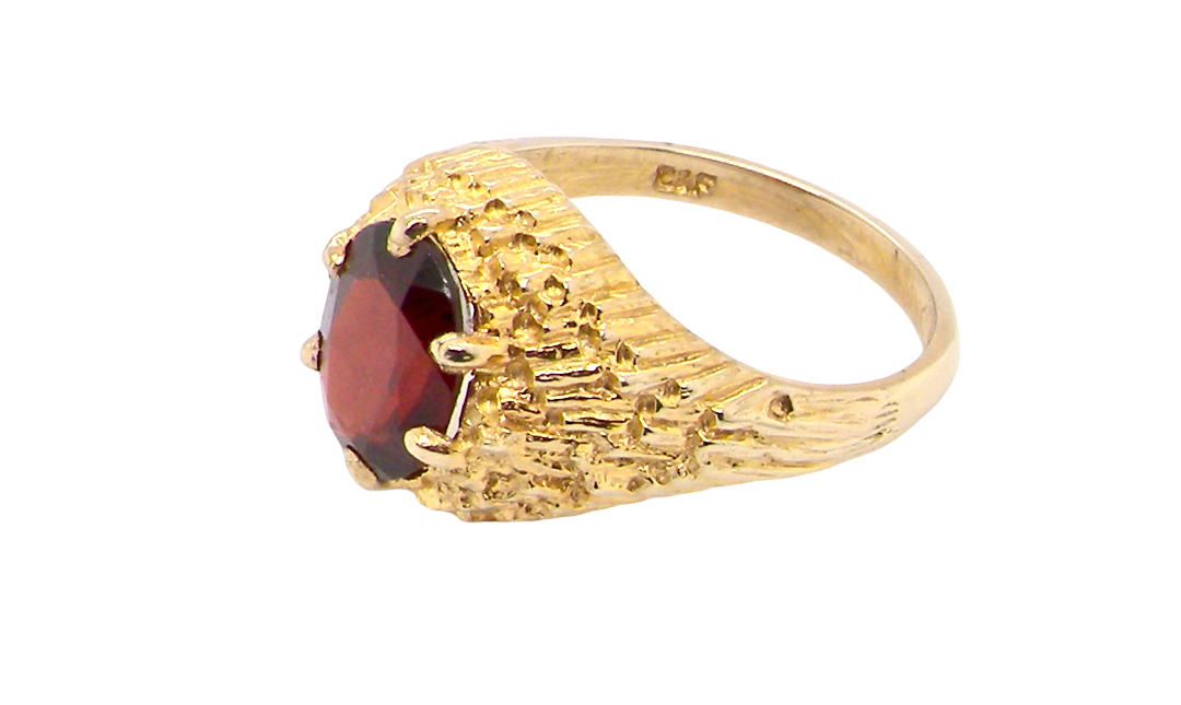 side A 1970s dress ring set with an oval garnet stone. This measures 10x8mm and claw set.