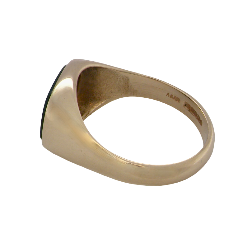 A gold signet ring with a dark green oval inlay, shown from a side angle on a plain white background.