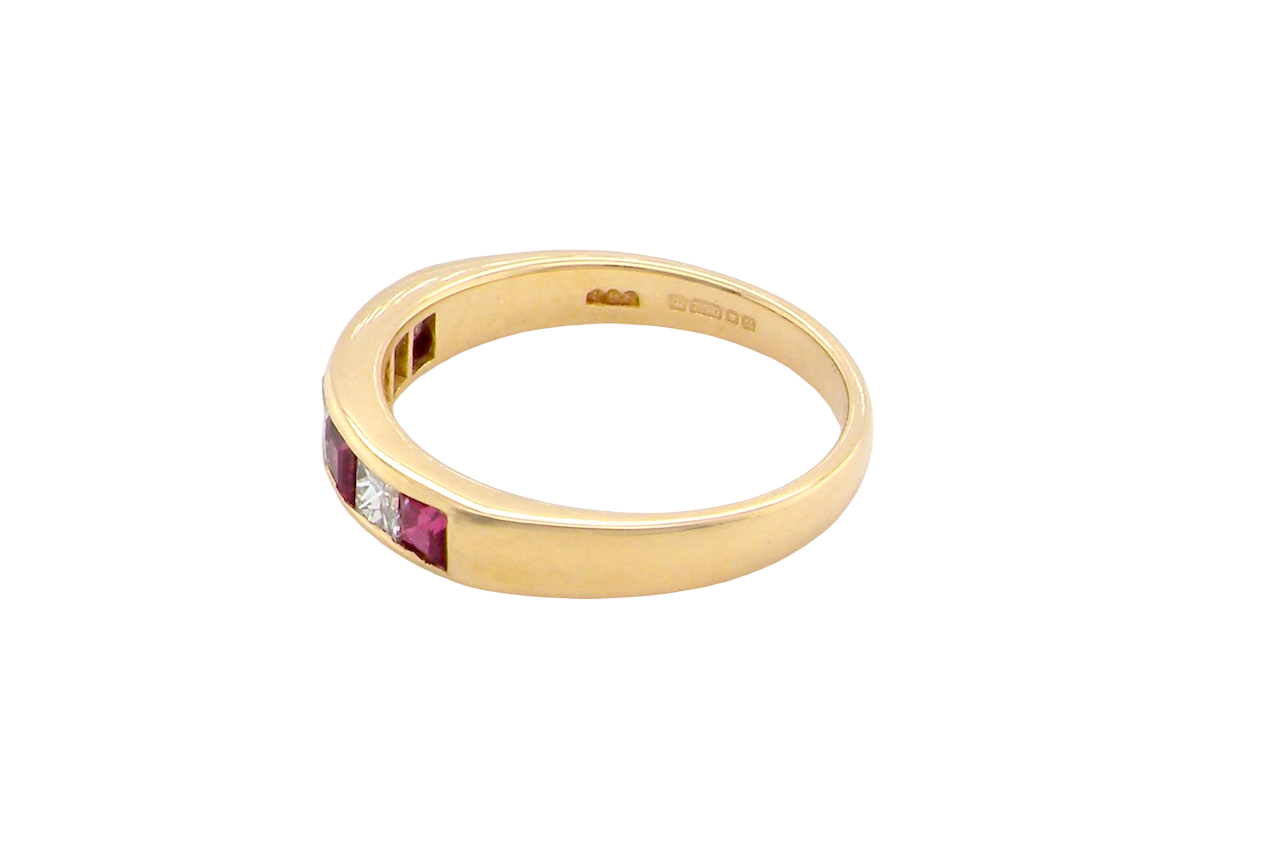 An 18-carat gold half-hoop eternity ring set with alternating rubies and diamonds.