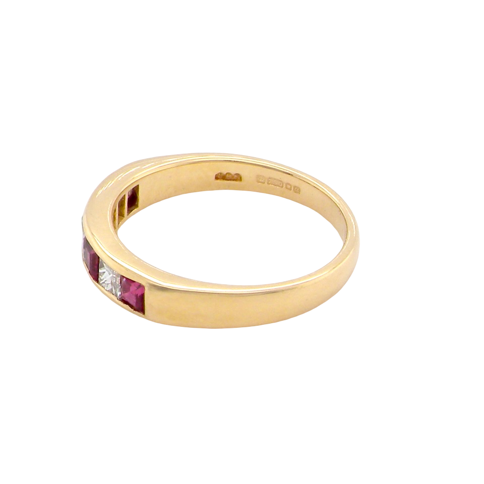 An 18-carat gold half-hoop eternity ring set with alternating rubies and diamonds.