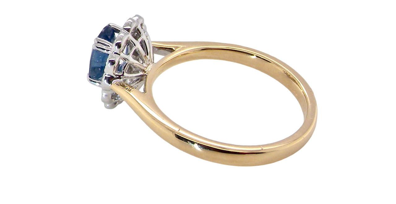 side A beautiful cluster ring featuring an oval-cut mid to dark blue sapphire measuring 7 × 5 mm (approximately ¾ carat).