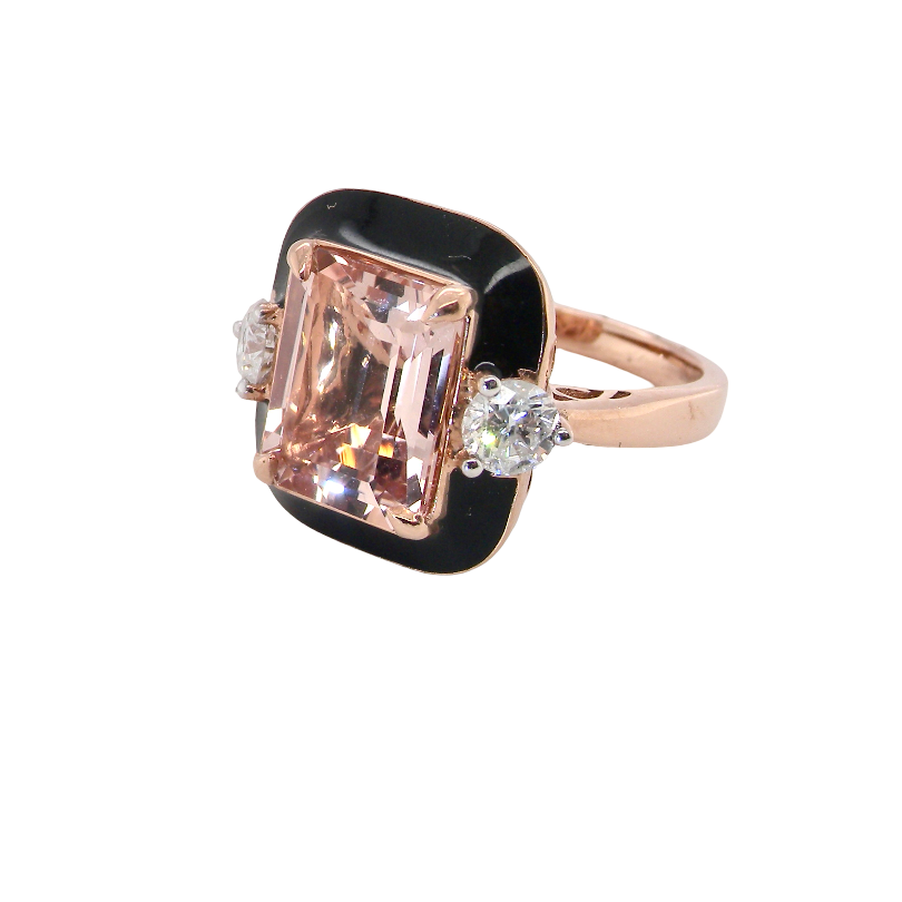A rose gold ring featuring a rectangular emerald-cut pink gemstone in a bezel setting with a black enamel border, accented by two small round clear stones on either side, shown on a plain white background.