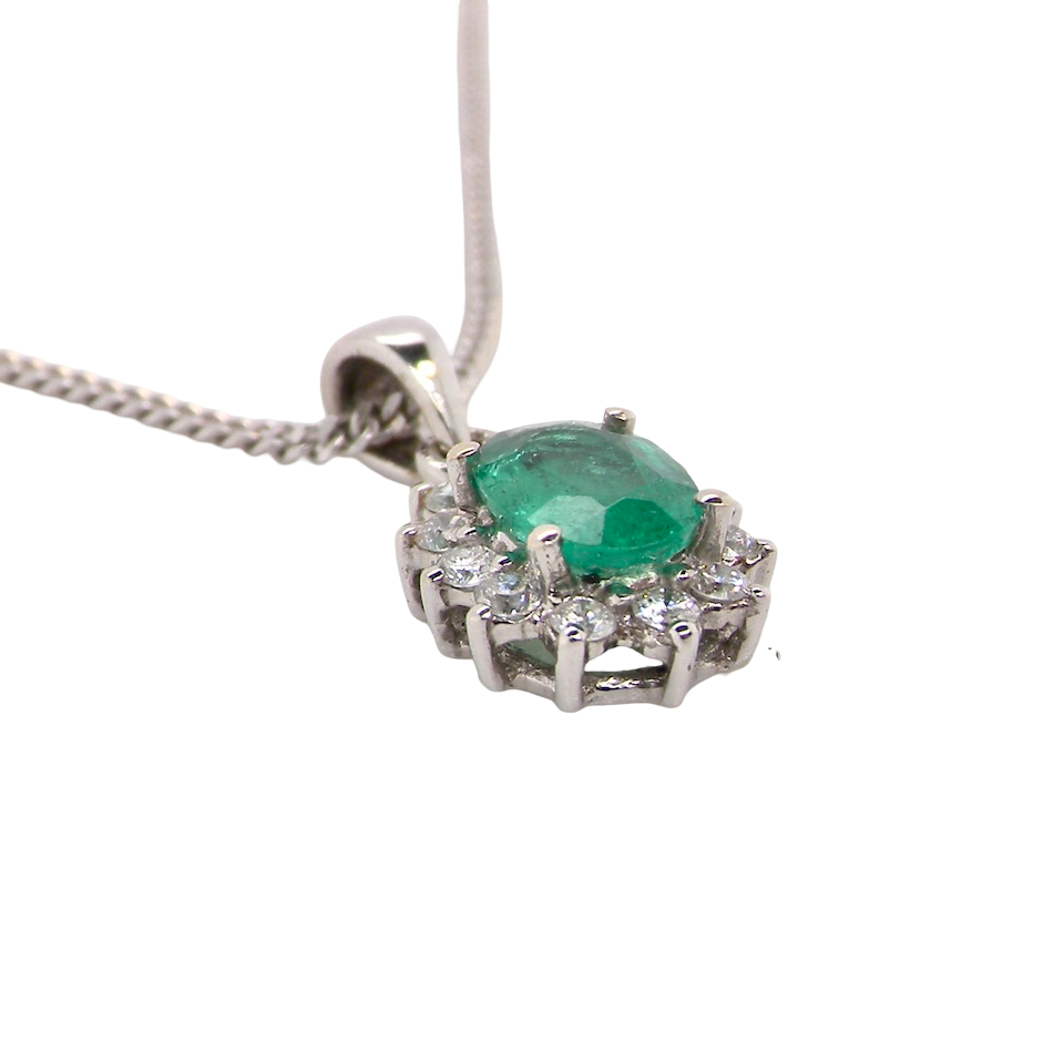 side A beautiful traditional cluster pendant featuring a vibrant oval-cut emerald