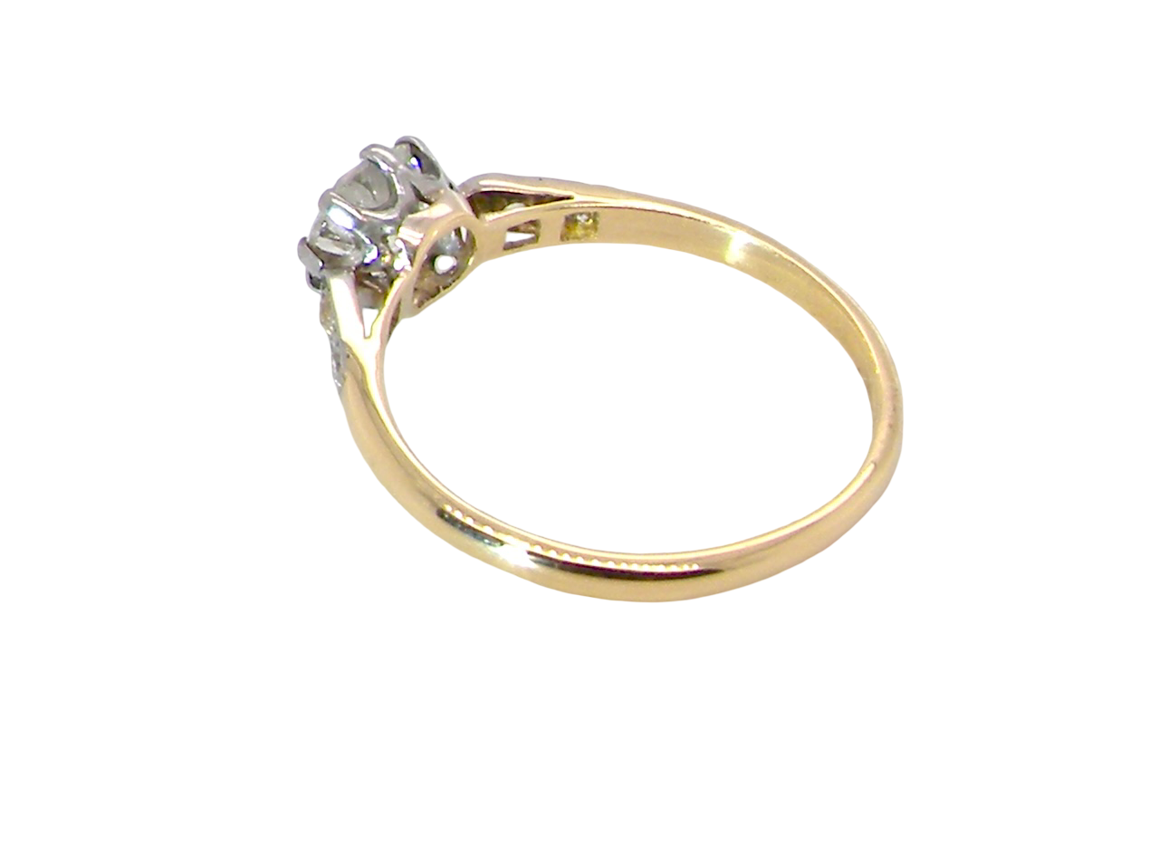 side A beautifully elegant vintage solitaire ring dating to the 1930s, showcasing a classic old brilliant-cut white diamond.
The centre diamond measures approximately 6.2mm