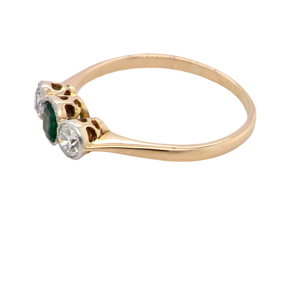 side A charming ring dating from the early to mid-20th century, beautifully crafted and full of period character.
The centrepiece is a vivid bright-green, cushion-shaped emerald