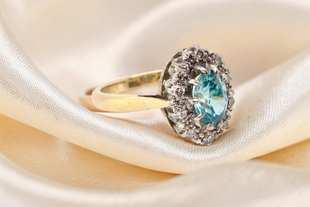 side A cluster ring set with a natural blue zircon centre stone, 7.5x5mm, vibrant aquamarine colour. 