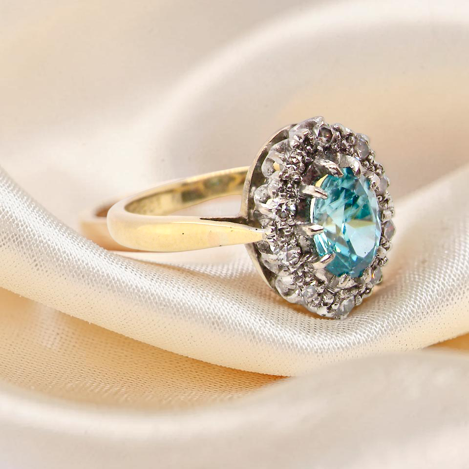 side A cluster ring set with a natural blue zircon centre stone, 7.5x5mm, vibrant aquamarine colour. 