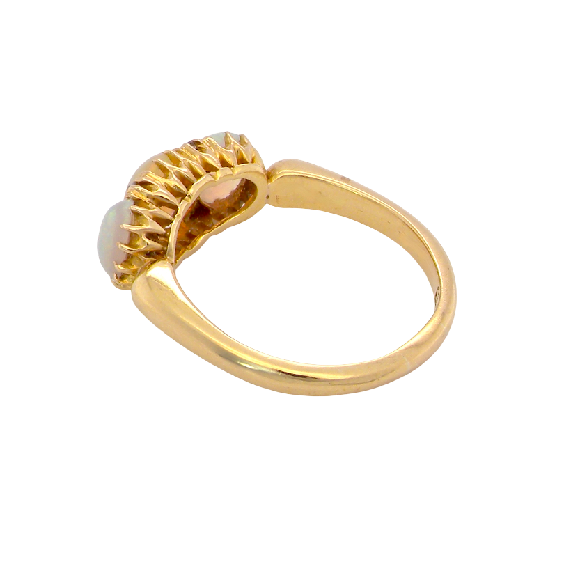A gold ring with a textured, scalloped setting holding a round white opal gemstone, shown on a plain white background.