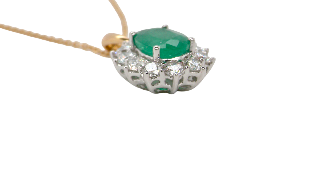 side A fine cluster pendant. Features at the centre an oval cut emerald, measures 7.5x5mm (est one carat). Dark green hue, natural inclusions.