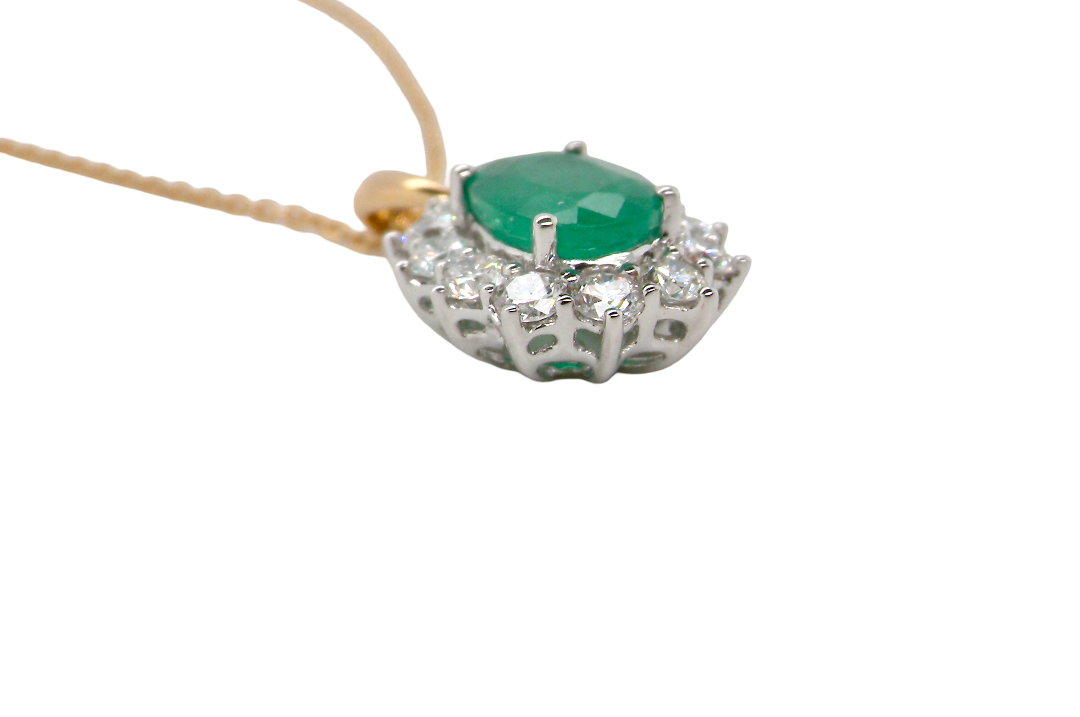 side A fine cluster pendant. Features at the centre an oval cut emerald, measures 7.5x5mm (est one carat). Dark green hue, natural inclusions.