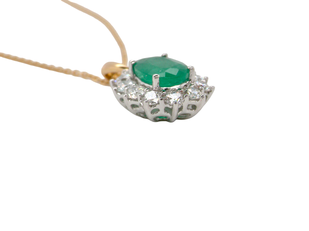side A fine cluster pendant. Features at the centre an oval cut emerald, measures 7.5x5mm (est one carat). Dark green hue, natural inclusions.