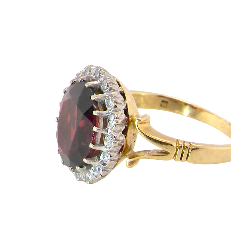 side A fine cluster ring. Features a large garnet centre stone
Complimented by an outer halo of white diamonds. 