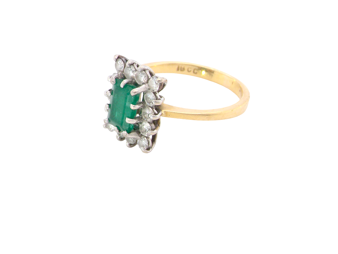 side A fine cluster ring that features a rectangular mid to dark green emerald, measures 8x6mm (est 0.50 carats) 
