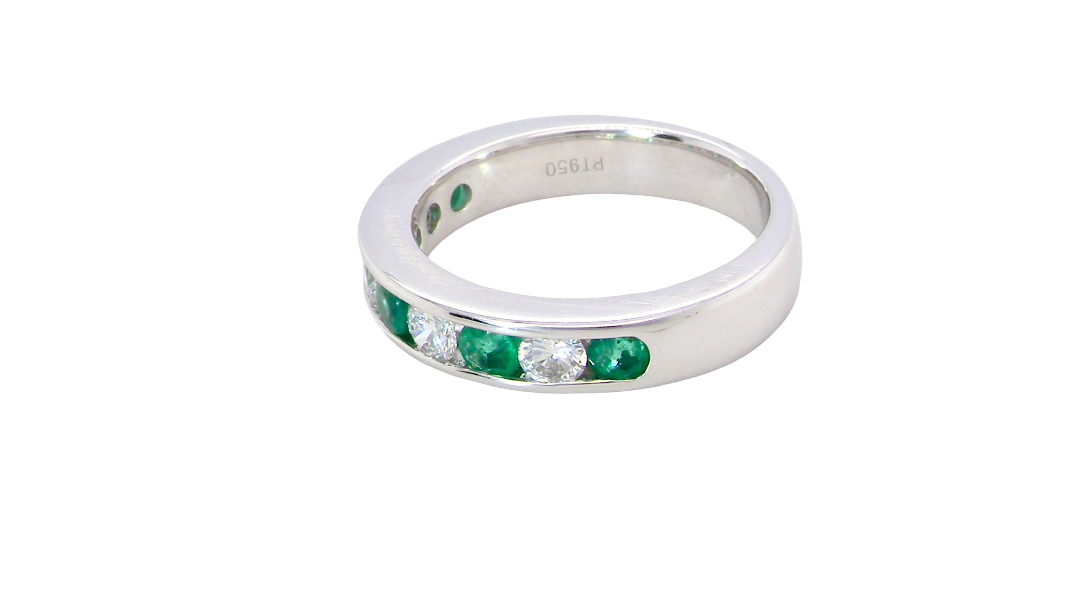 side A fine platinum half hoop eternity ring. This is a new ring*. Channel set gem stones, five bright green emeralds 2.6mm each (0.54 carats total)