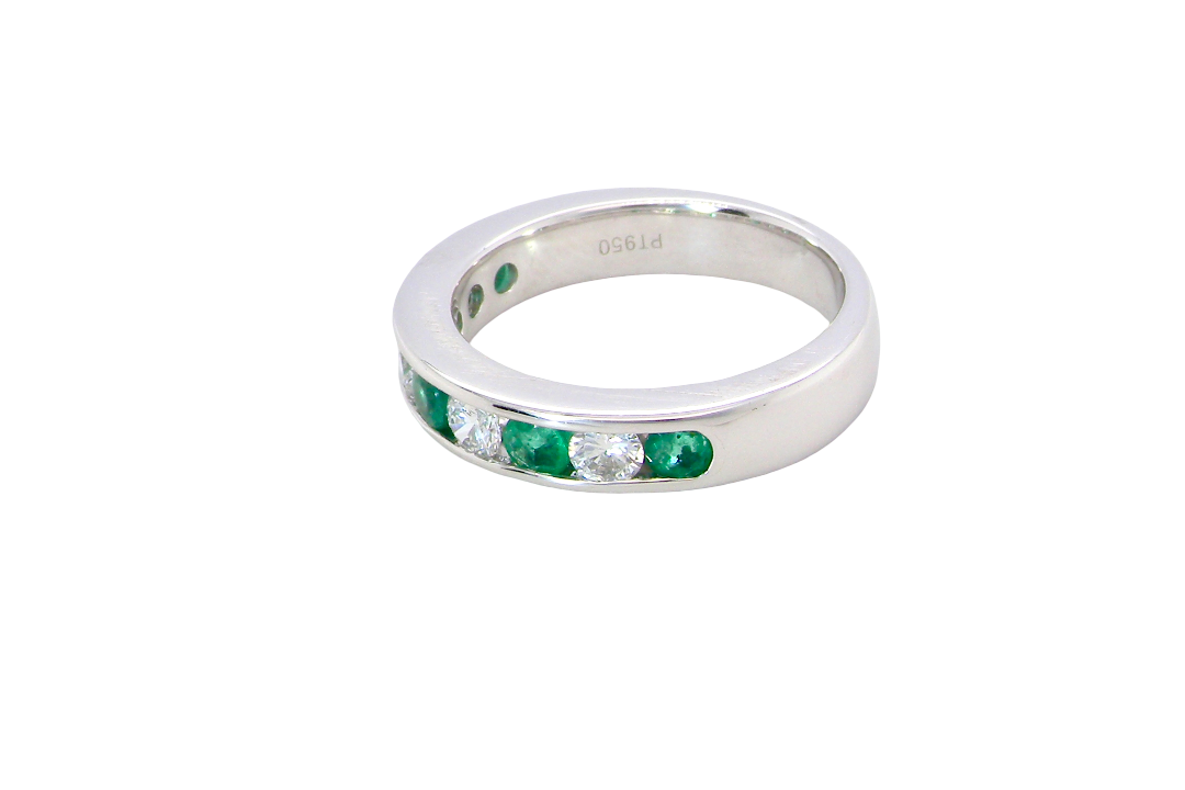 side A fine platinum half hoop eternity ring. This is a new ring*. Channel set gem stones, five bright green emeralds 2.6mm each (0.54 carats total)