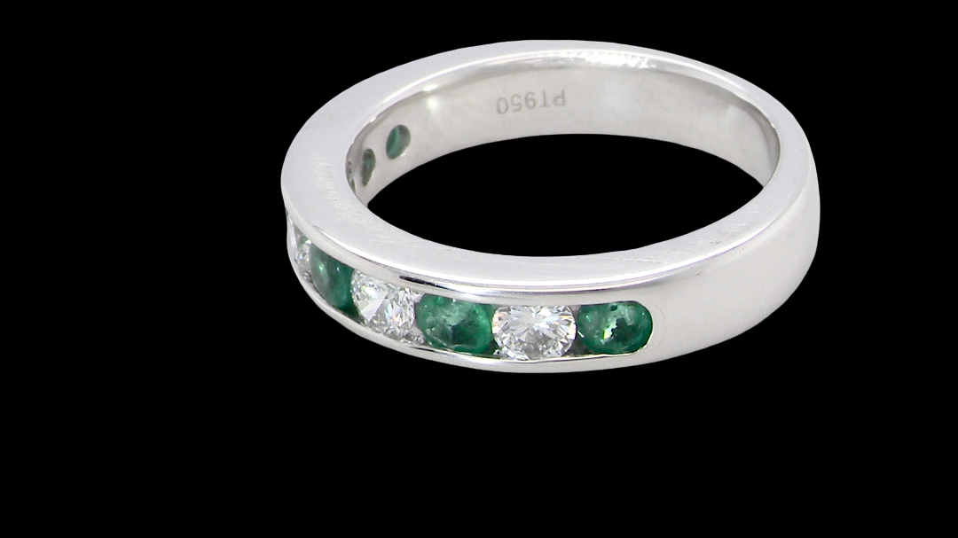 side A fine platinum half hoop eternity ring. This is a new ring*. Channel set gem stones, five bright green emeralds 2.6mm each (0.54 carats total)