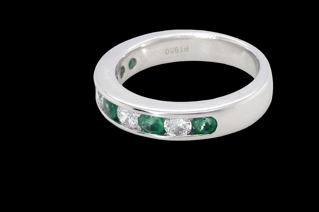 side A fine platinum half hoop eternity ring. This is a new ring*. Channel set gem stones, five bright green emeralds 2.6mm each (0.54 carats total)