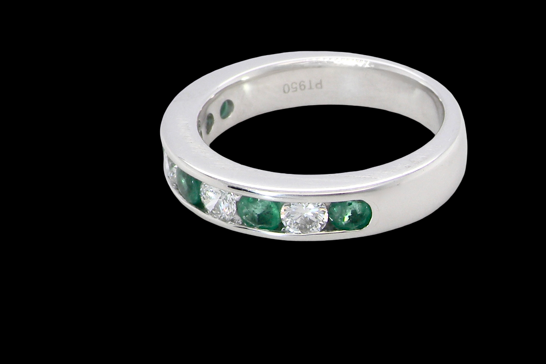 side A fine platinum half hoop eternity ring. This is a new ring*. Channel set gem stones, five bright green emeralds 2.6mm each (0.54 carats total)