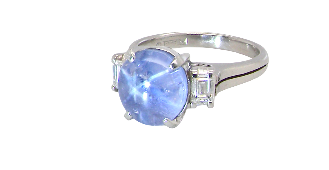 side A fine platinum* ring. Features a lovely sky blue sapphire with 'star sapphire ' chatoyancy , measures 10x9mm, (est 4 carats) held by four claws, cabouchon cut
