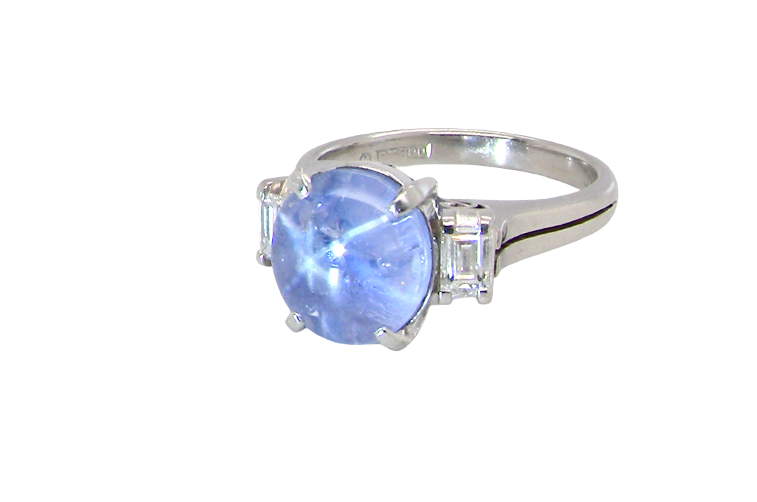 side A fine platinum* ring. Features a lovely sky blue sapphire with 'star sapphire ' chatoyancy , measures 10x9mm, (est 4 carats) held by four claws, cabouchon cut