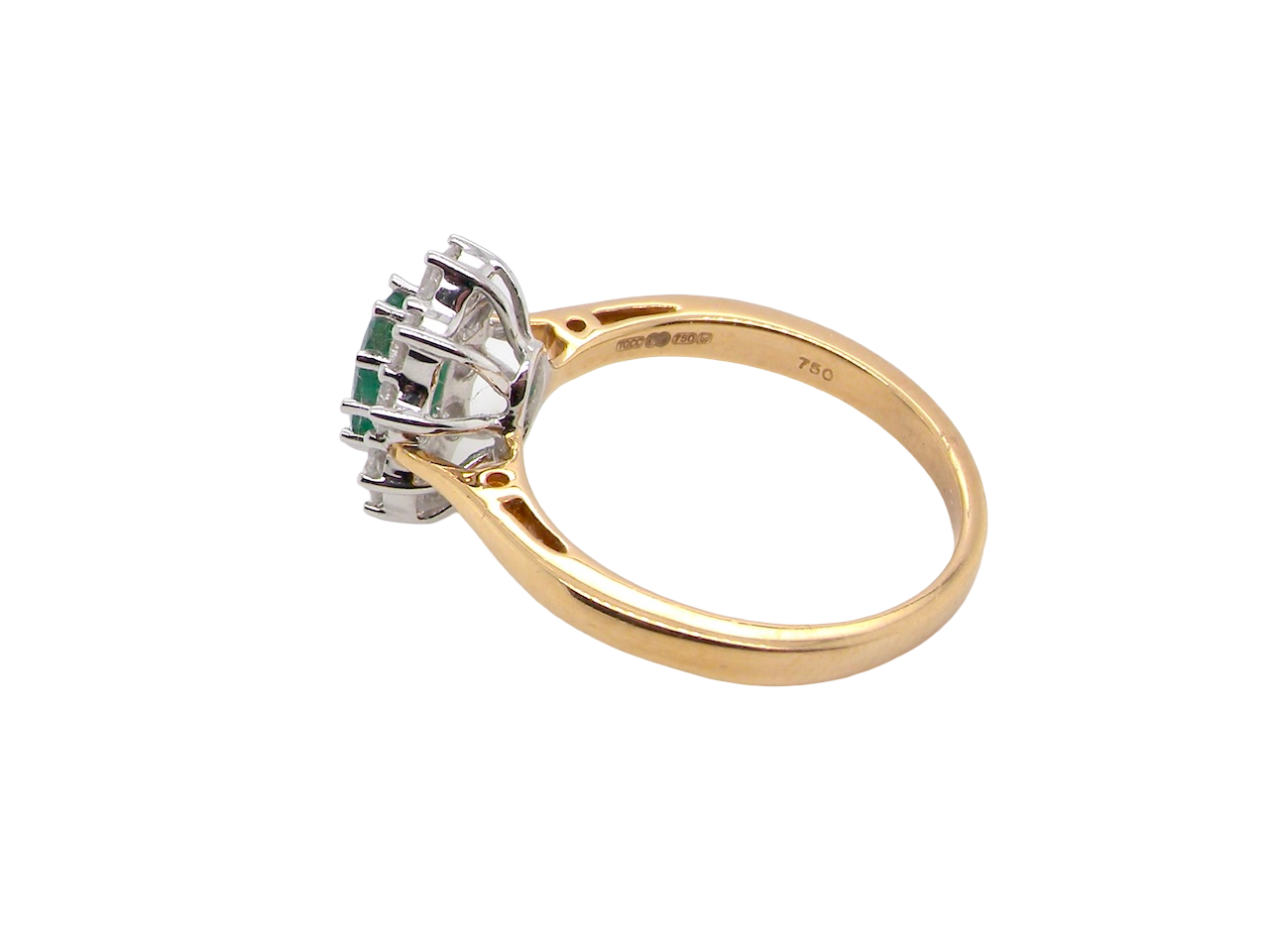 side A fine traditional emerald and diamond cluster ring, featuring a vibrant oval-cut emerald to the centre measuring approximately 7 × 5 mm