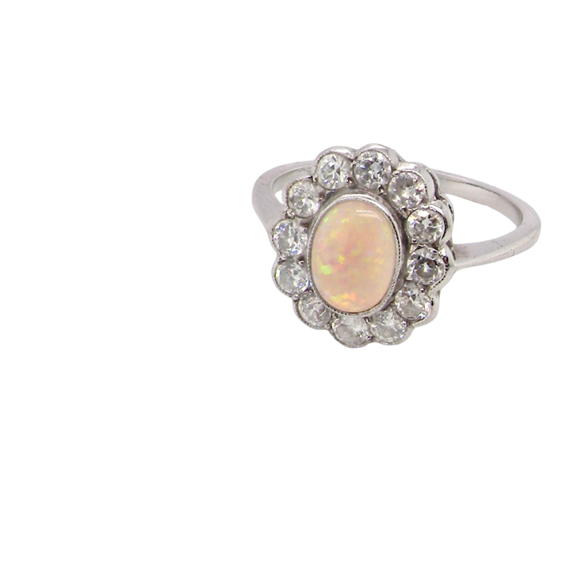 side A fine vintage cluster ring. Features to the centre an oval shaped opal, with excellent play of colour, pink to one way, vibrant green to the other with flashes of electric blue also within the body of the gem.