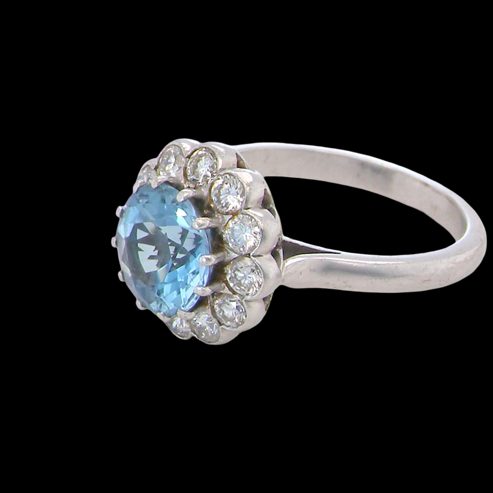 side A fine vintage cluster ring centred with a deep blue aquamarine, measuring approximately 8mm and estimated at 2 carats, securely claw set.