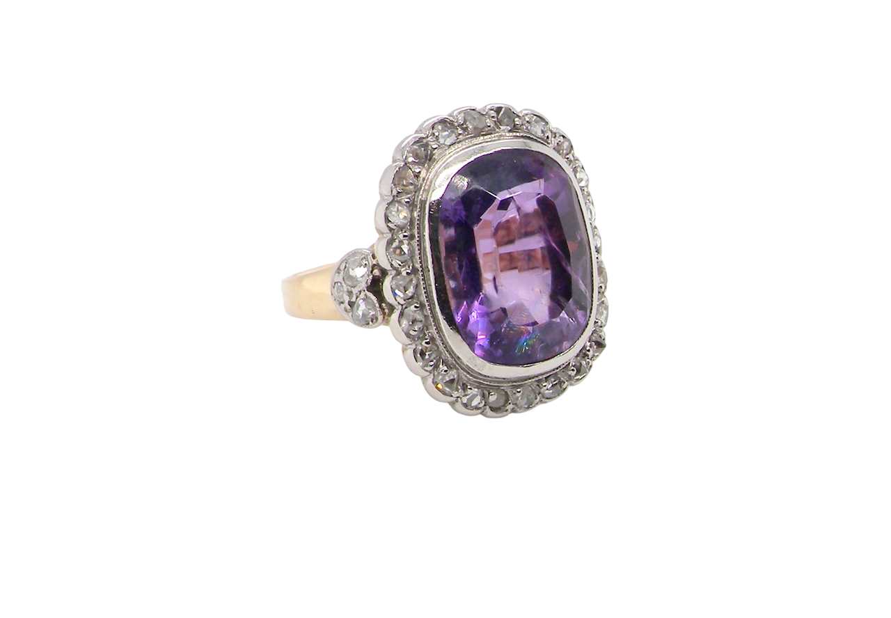 side A fine vintage ring. Features to the centre a large cushion shaped amethyst, 13x10mm, rim setting.