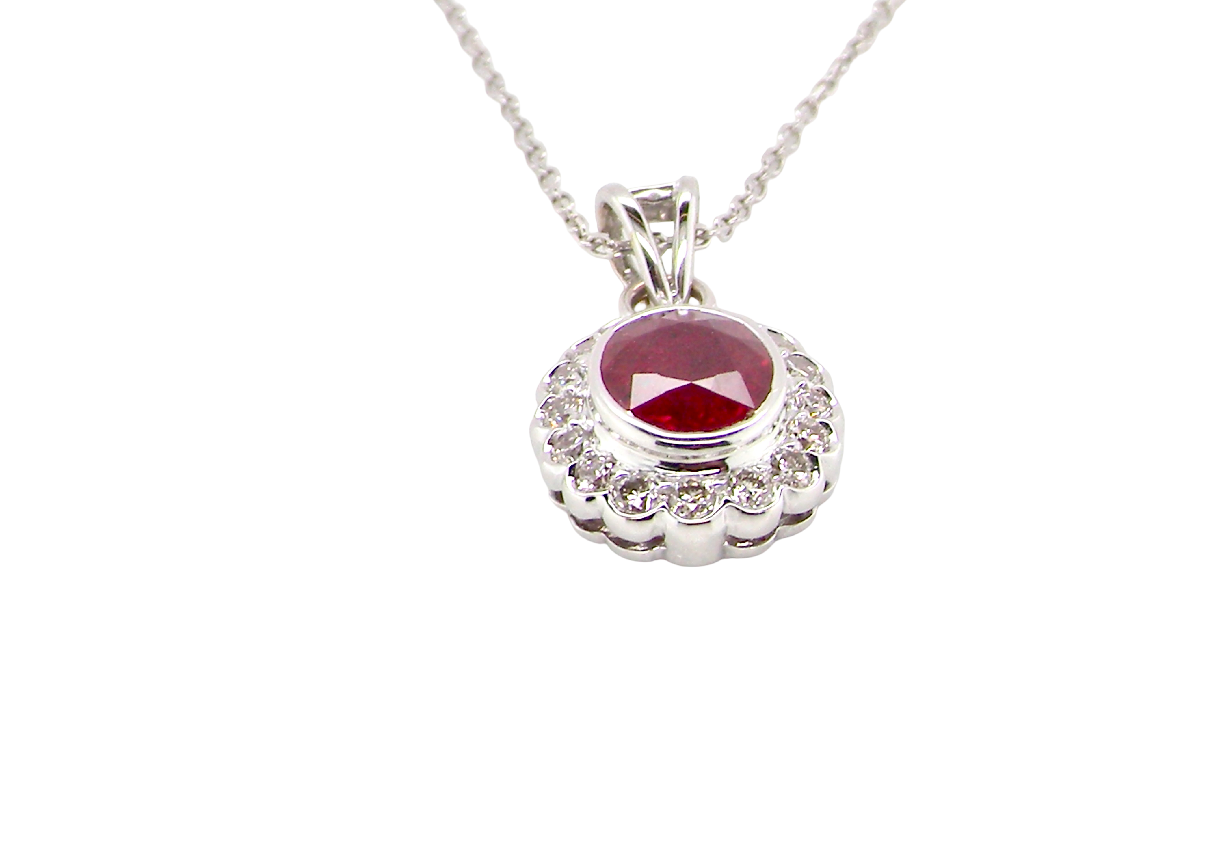 side A fine white gold pendant that features to the centre an oval facet cut ruby, 8x6mm (est 1.25 carats) good deep red colour.