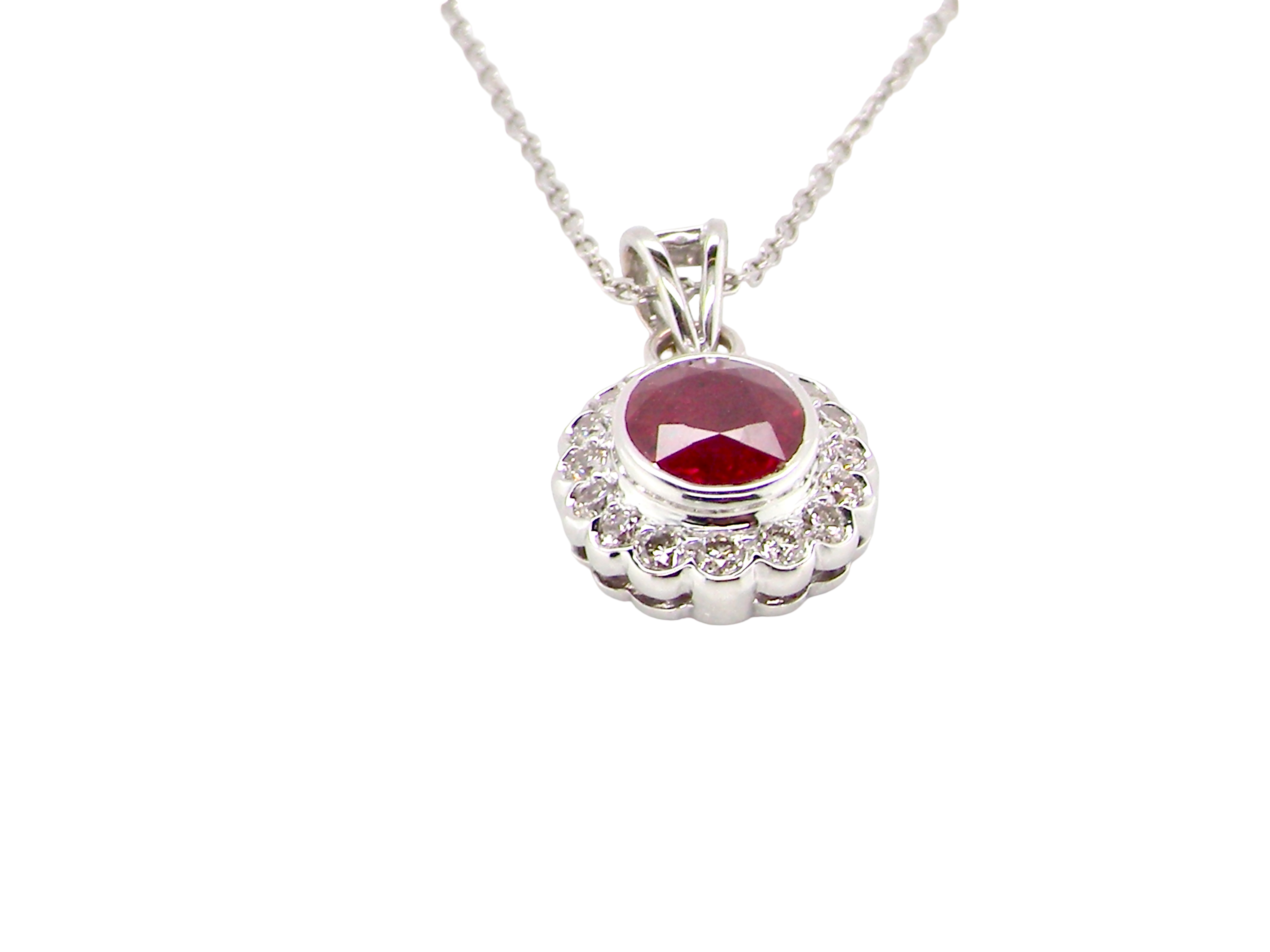 side A fine white gold pendant that features to the centre an oval facet cut ruby, 8x6mm (est 1.25 carats) good deep red colour.