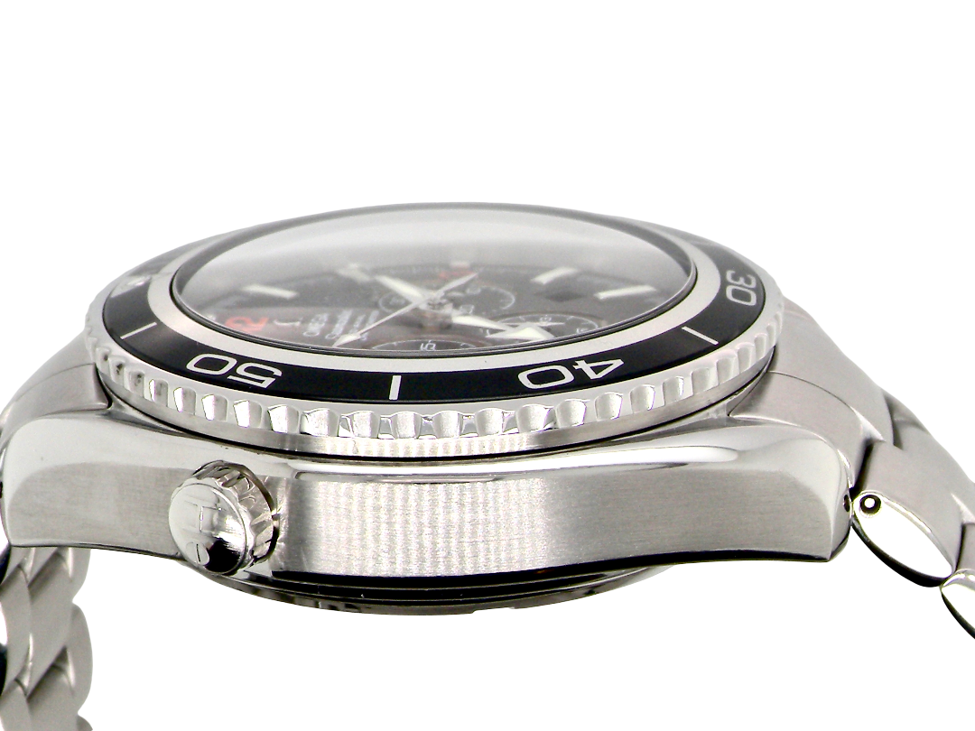Close-up side view of a stainless steel wristwatch with a black bezel, silver case, and metal link bracelet on a white background.