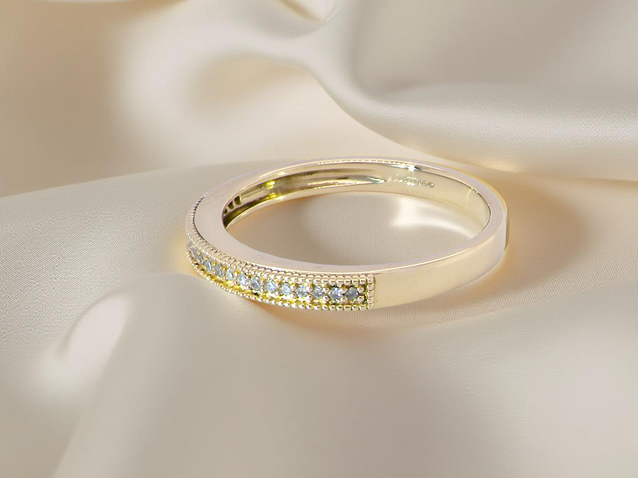 side A half-hoop eternity ring set with approximately twenty-four white diamonds