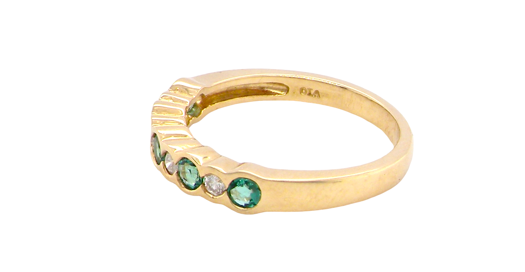 side A half hoop eternity ring. Set with five round emeralds, each 3mm (0.10 carats) and set with an alternate brilliant cut white diamond, 2.4mm each (total 0.20 carats)
