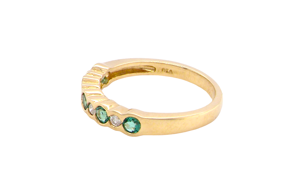 side A half hoop eternity ring. Set with five round emeralds, each 3mm (0.10 carats) and set with an alternate brilliant cut white diamond, 2.4mm each (total 0.20 carats)