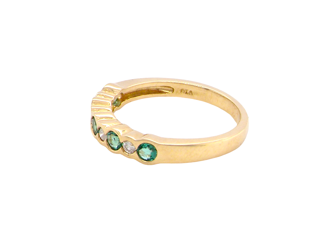 side A half hoop eternity ring. Set with five round emeralds, each 3mm (0.10 carats) and set with an alternate brilliant cut white diamond, 2.4mm each (total 0.20 carats)