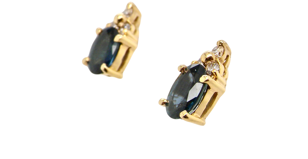 side A pair of 18 carat gold earrings*. Set with a dark blue oval cut sapphire 6x4mm, claw set.
Above each, three small white diamonds, overall size 9x4.6mm, weight each 1 gram.