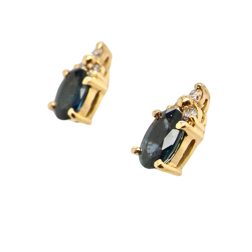 side A pair of 18 carat gold earrings*. Set with a dark blue oval cut sapphire 6x4mm, claw set.
Above each, three small white diamonds, overall size 9x4.6mm, weight each 1 gram.
