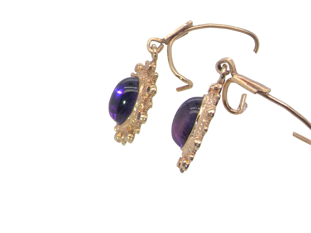 side A pair of drop earrings. Each set with a cabouchon cut amethyst 6x4mm and set with an antique look border.